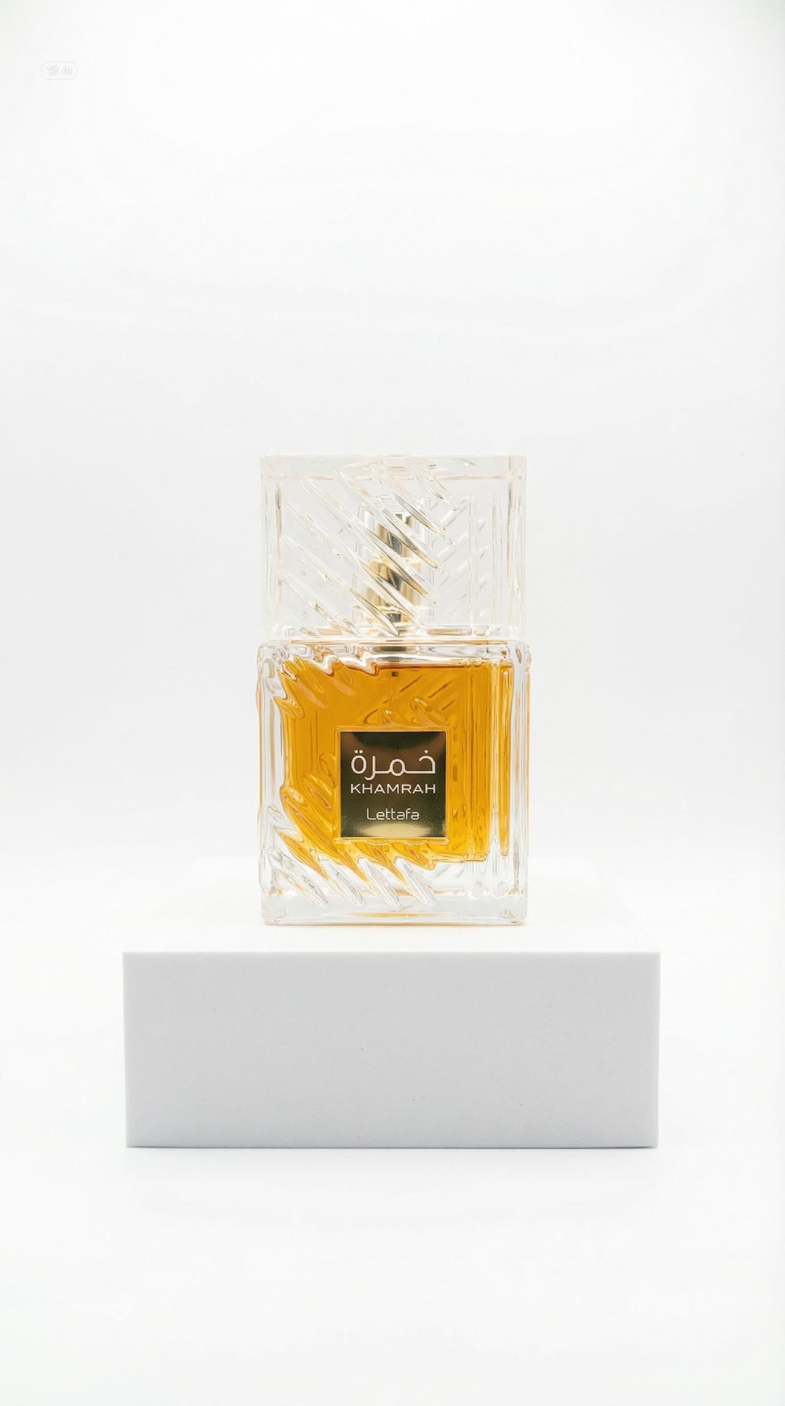 Lattafa Khamrah perfume in a clear cut-glass bottle on a white plinth