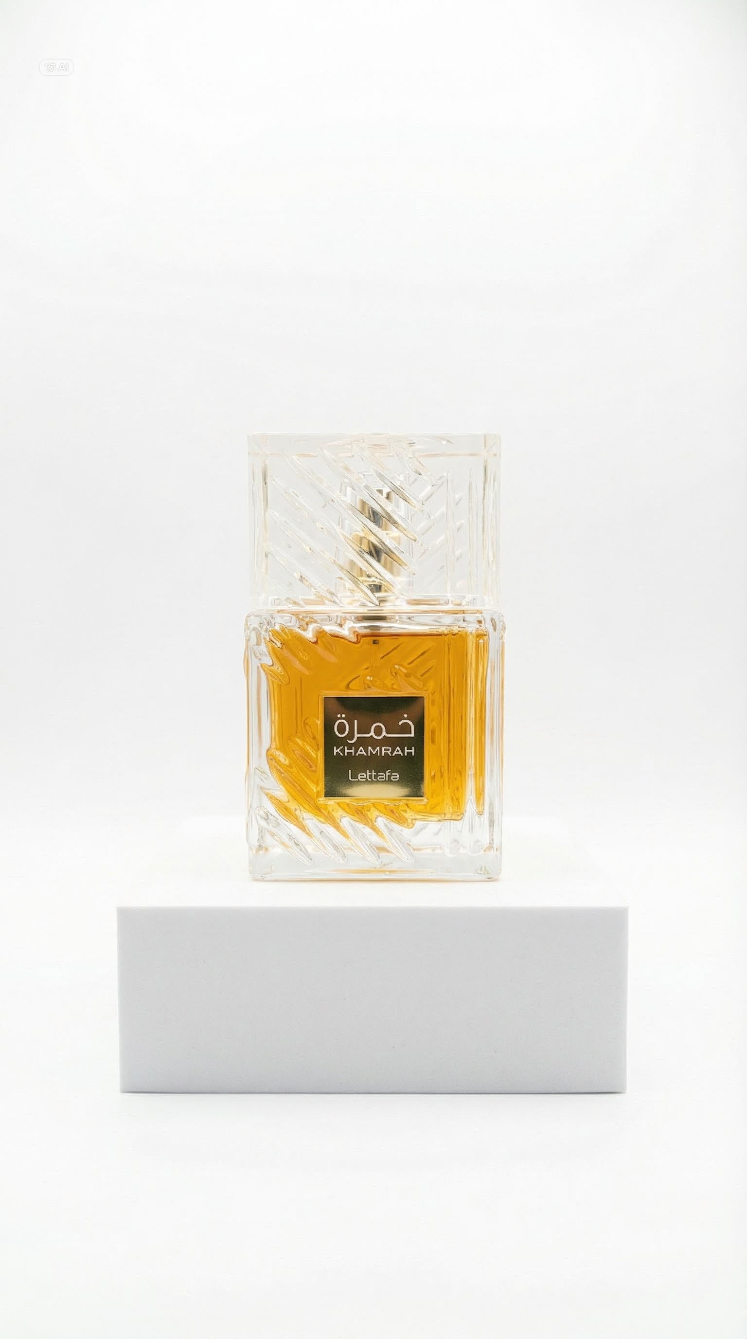 Lattafa Khamrah perfume in a clear cut-glass bottle on a white plinth